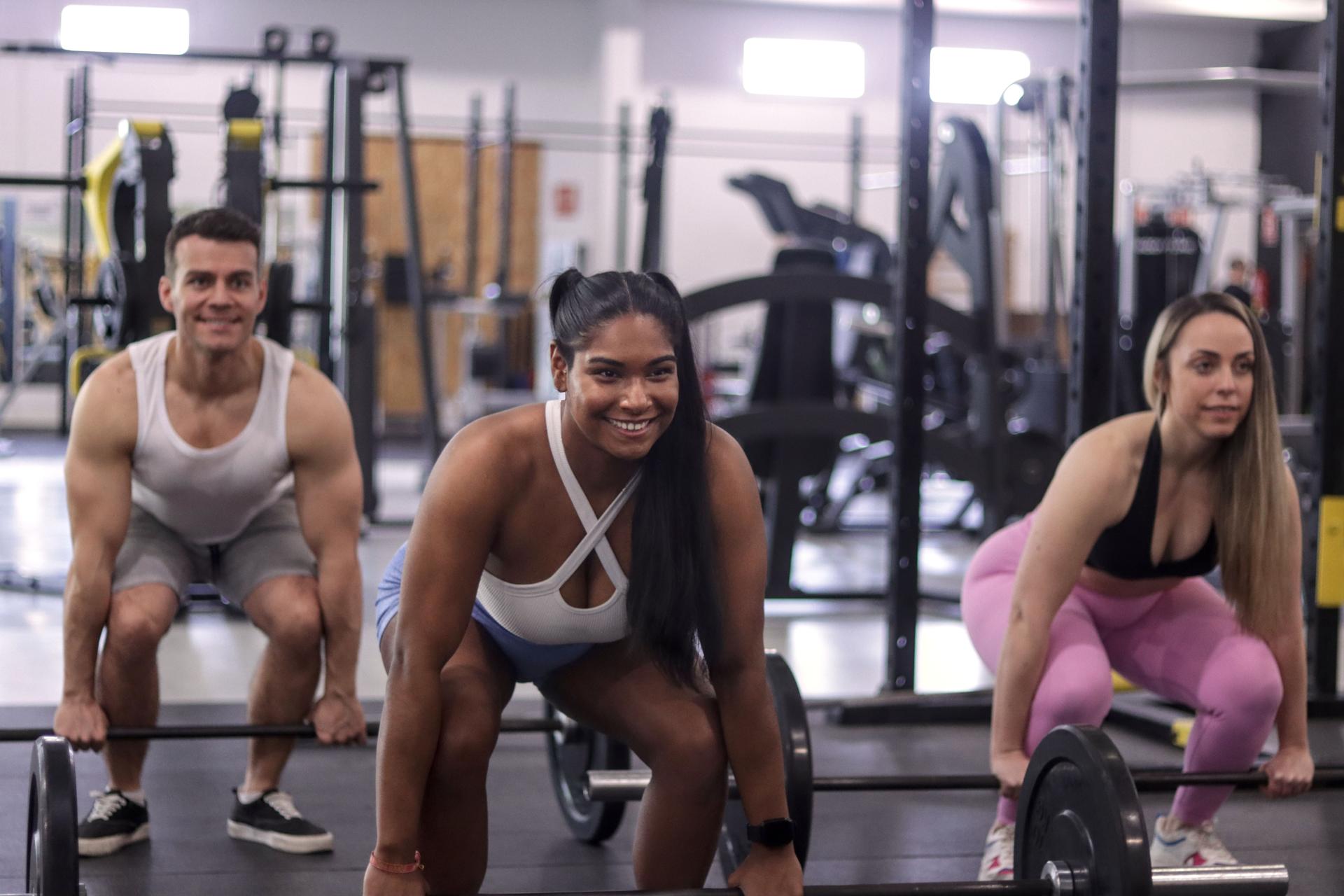 Group of multiracial smiling people doing dead lift
