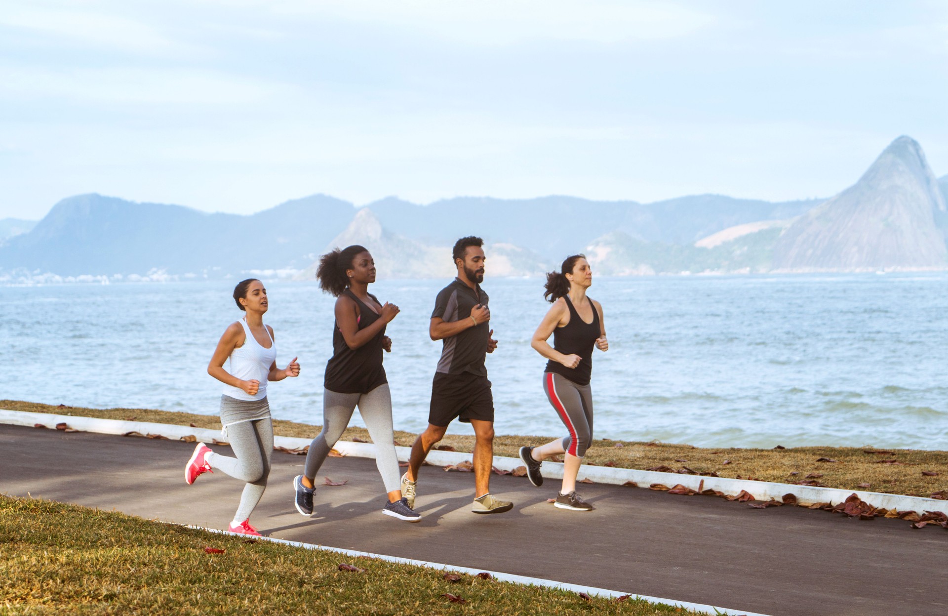 brazilian friends jogging at beach against sky